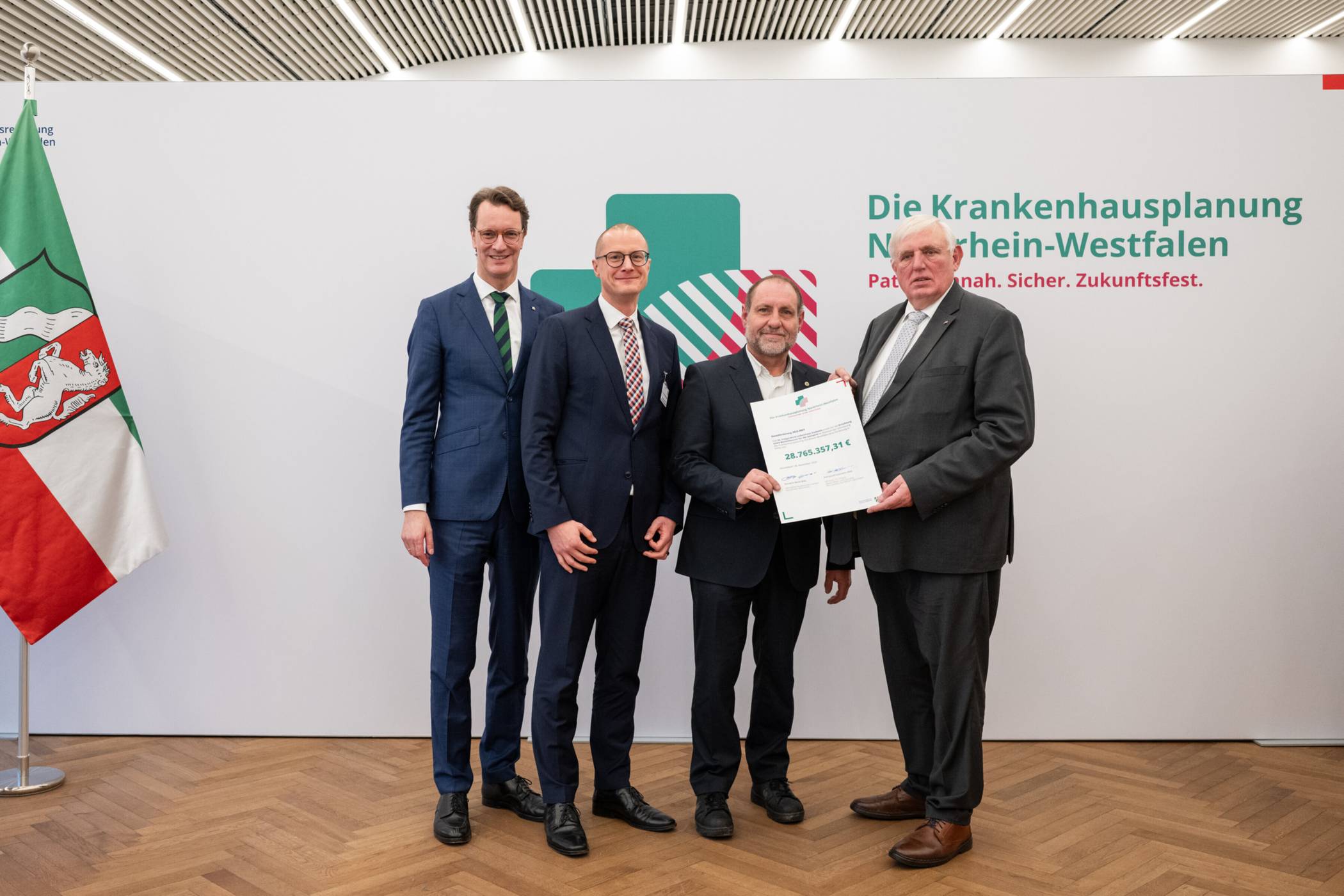 Feierliche Übergabe des Förderbescheids in Düsseldorf: NRW-Ministerpräsident Hendrik Wüst MdL, Regionalgeschäftsführer der St. Franziskus Stiftung Münster Dr. Conrad Middendorf, der Kaufmännische Direktor des St. Irmgardis-Krankenhauses Süchteln Thomas Becker und NRW-Gesundheitsminister Karl-Josef Laumann MdL. Foto: Land NRW - Mark Hermenau
