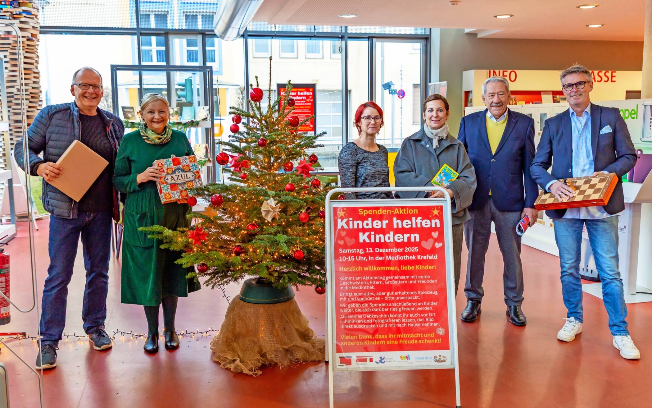 Laden alle Kinder zum Spielzeugspenden ein (v.l.): Peter Lengwenings (Freunde und Förderer der Mediothek Krefeld sowie Kengerdruum Krieewel), Brigitte Schäfers (Freunde und Förderer der Mediothek), Dr. Lisa Beutelspacher (Mediothek Krefeld), Tanja Kirsch-Boy (Schlaue Löffel e.V.), Dr. Robert Schäfer  (Kengerdruum Krieewel) sowie  Jochen Rausch (Bürgerstiftung Krefeld).