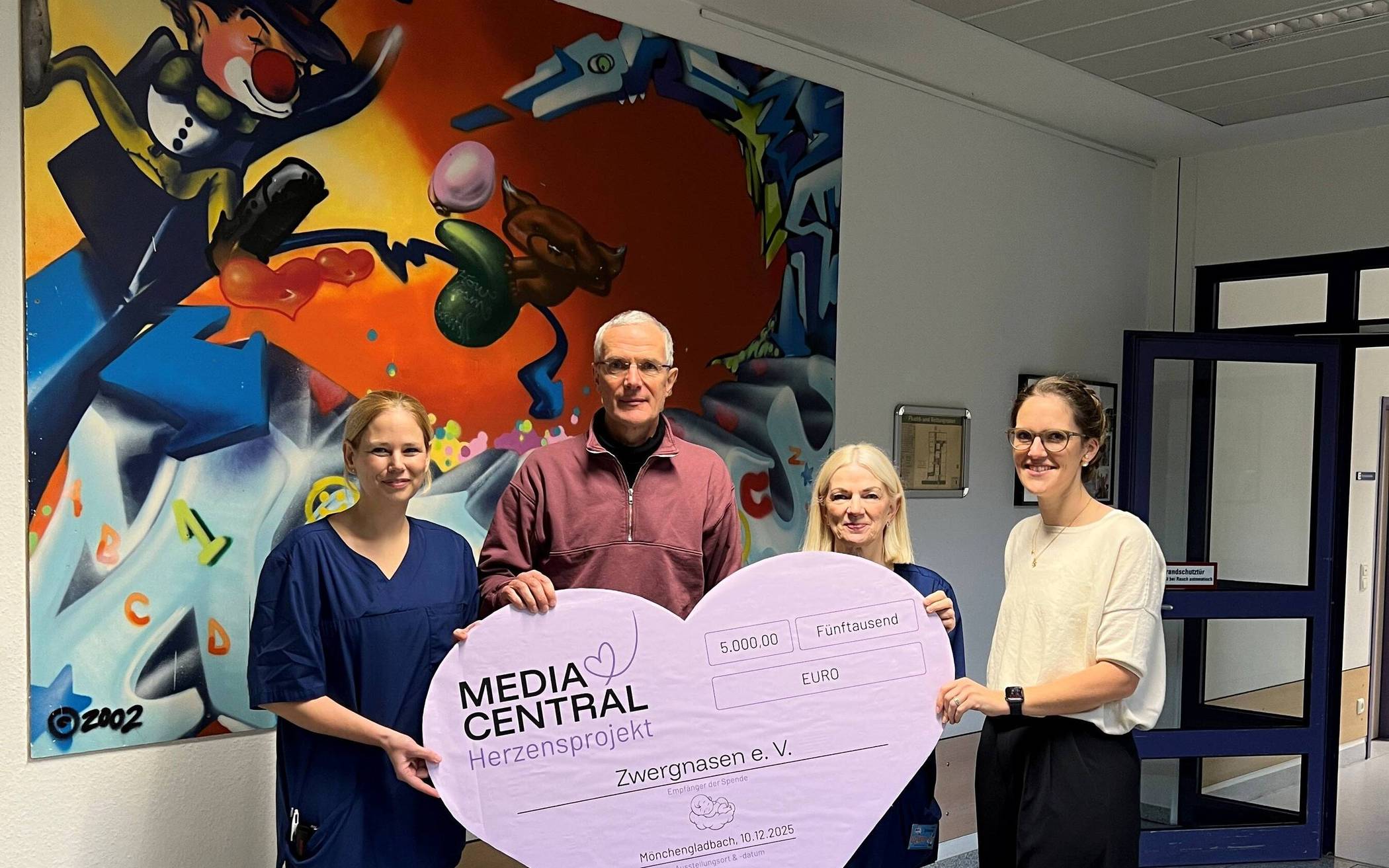  Lisa Sussmann, Projektleiterin des MEDIA CENTRAL Herzensprojekts, überreicht die Spende stellvertretend an den Vorstand von Zwergnase e.V. mit Dr. med. Jürgen Wintgens, Petra Kurt (l.) sowie an Dr. med. Anja Jaeger (3.v.l.).  