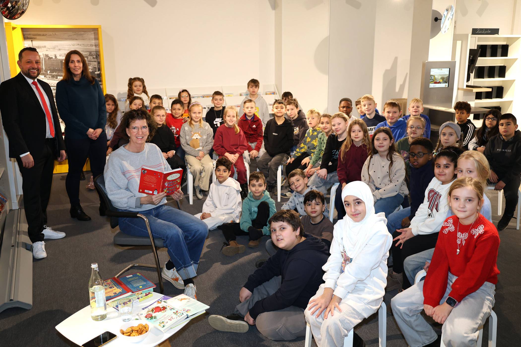  Auch die Autorin Barbara Zoschke war bei den Repelener Schullesungen dabei, hier mit den Kindern der Klassen 3a und 3c der Regenbogenschule. Markus Schürmann, Leiter der Sparkassen-Geschäftsstelle Repelen, und Sabine Ließfeld, Leiterin Bibliothekszweigestelle Repelen, freuen sich über den Erfolg der Reihe. 