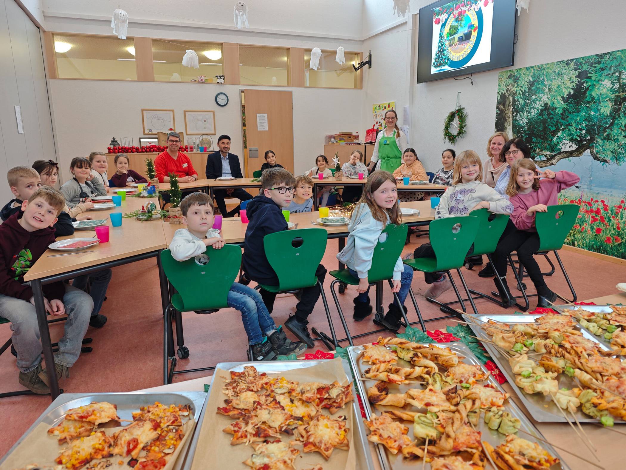  Kinder der OGS Kettelerstraße mit ihren erwachsenen Gästen (von links) Alexander Stiller-Bach (Leiter OGS Kettelerstraße), Sozialdezernent Ertunç Deniz, Nina Dohmen (städtische Beauftragte für Schulverpflegung). Katrin Liegner (stellvertretende Fachbereichsleiterin Schulverwaltung) sowie Hiltrud Bock (Schulleiterin GGS Dülken).  