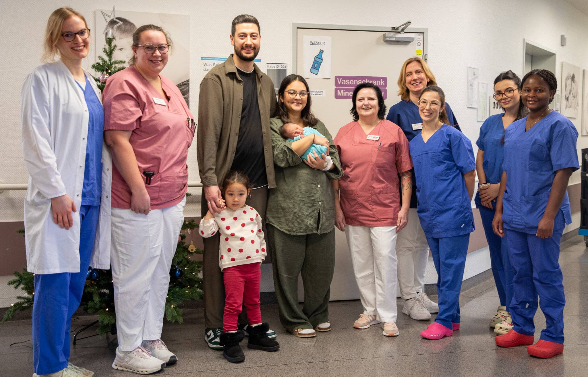  Dr. Dorit Brunotte, Leitende Oberärztin der Klinik für Gynäkologie, Geburtshilfe, Gynäkologische Onkologie &amp; Senologie (4. v.r.), freut sich gemeinsam mit der Familie und einem Teil des Teams über die gut verlaufenen Geburten der insgesamt drei Neujahrsbabys. 