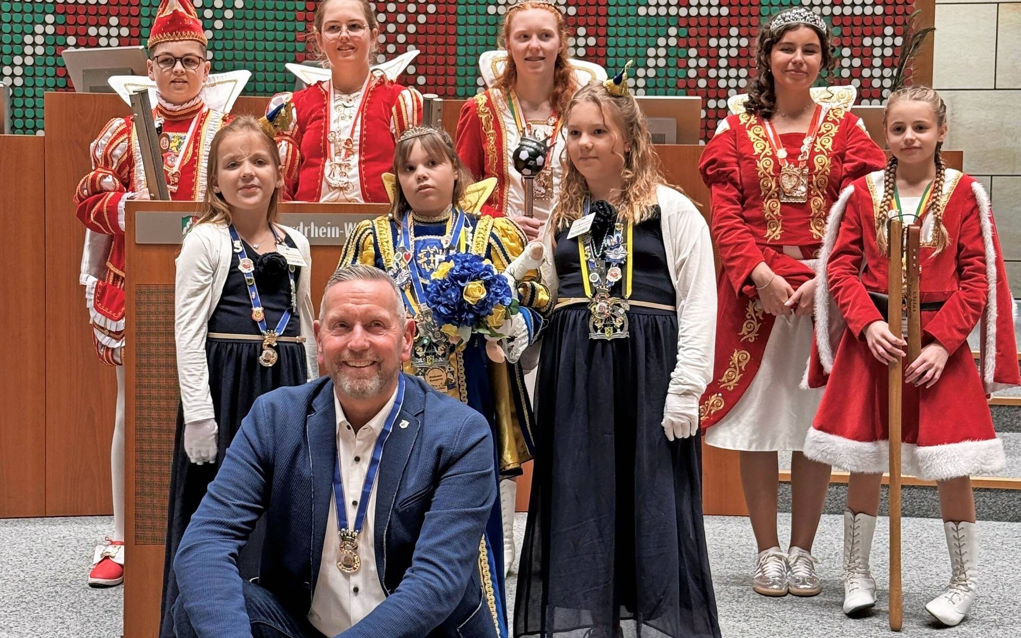 Unser Foto zeigt das Kinderprinzenpaar Moritz I. und Carolin I. (Viersen), das Dreigestirn Lina I., Abelina I. und Emma I. (Dülken) davor von links: Ministerin Tamina, Prinzessin Sharon I. und Ministerin Lisa (Willich) zusammen mit Guido Görtz MdL. Foto: Landtag