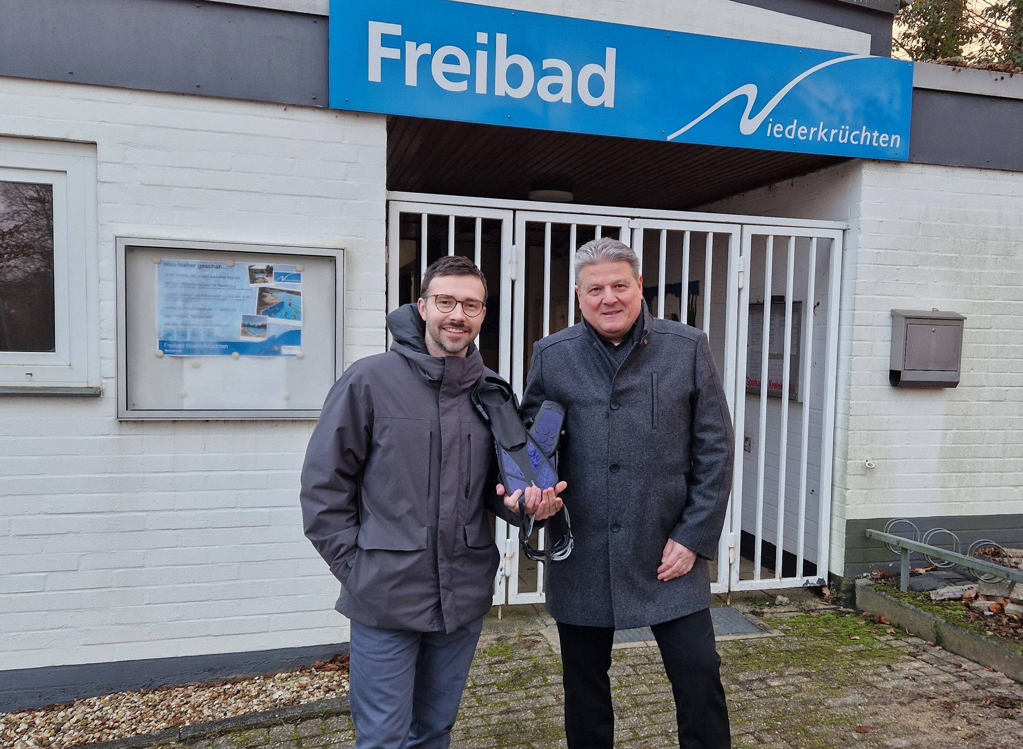 v.l.: Armin Brückner (Leiter Bäderbetrieb NEW mobil und aktiv Mönchengladbach GmbH) und Niederkrüchtens Bürgermeister Thomas Ricker vor dem Freibad in Niederkrüchten. 