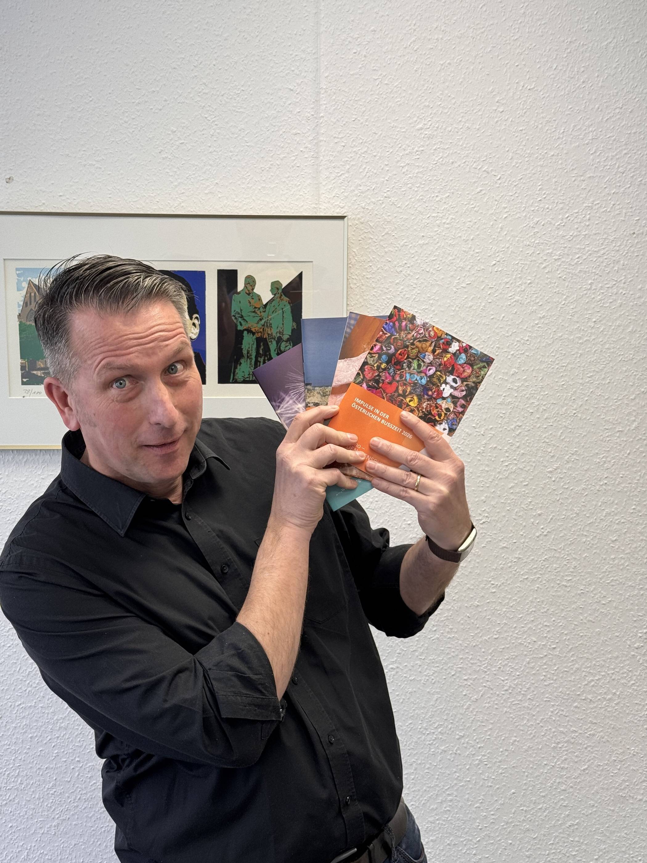 Michael Kock mit einigen der von ihm herausgegebenen Impuls-Hefte des Kolpingwerkes Aachen.  