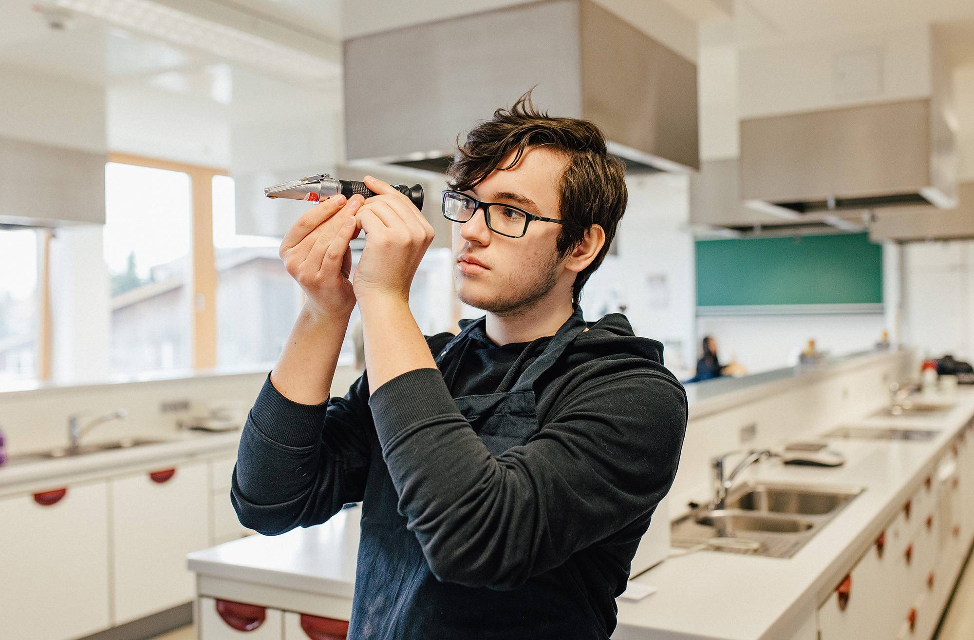  Ein Schüler misst den Zuckergehalt von Cola. 