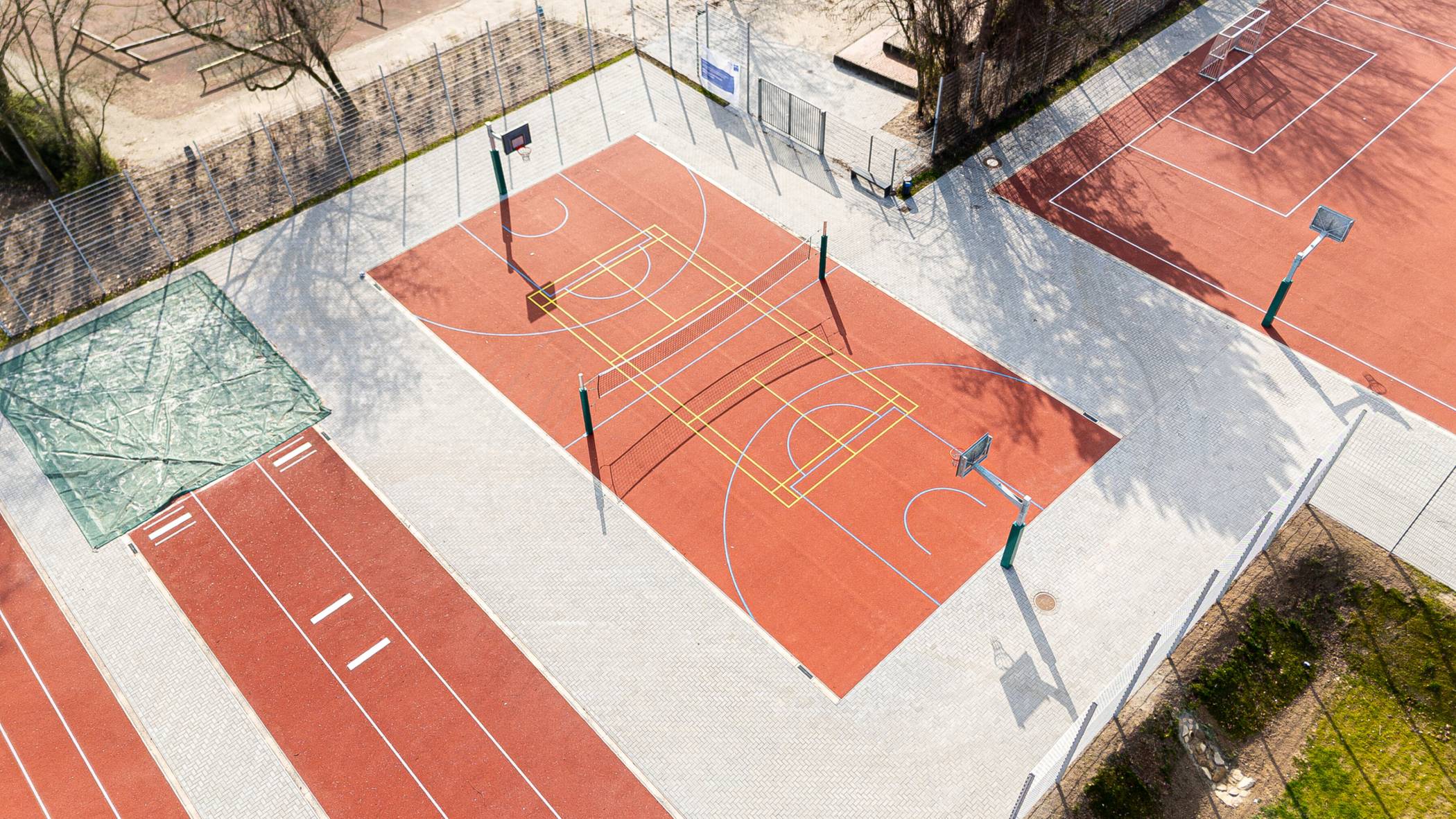  Das Foto zeigt beispielhaft einen Teil der sanierten Außensportanlagen an der Dahlingschule in Duisburg-Friemersheim. Die Anlagen wurden umfassend modernisiert und neugestaltet. Entstanden sind unter anderem neue Anlagen für Weitsprung, Kugelstoßen und Sprint sowie ein Schülerfußballfeld und ein Multifunktionsspielfeld – inklusive einer zeitgemäßen Unterkonstruktion mit moderner Entwässerung. Foto: Adrian Chodkowski / Wirtschaftsbetriebe Duisburg 