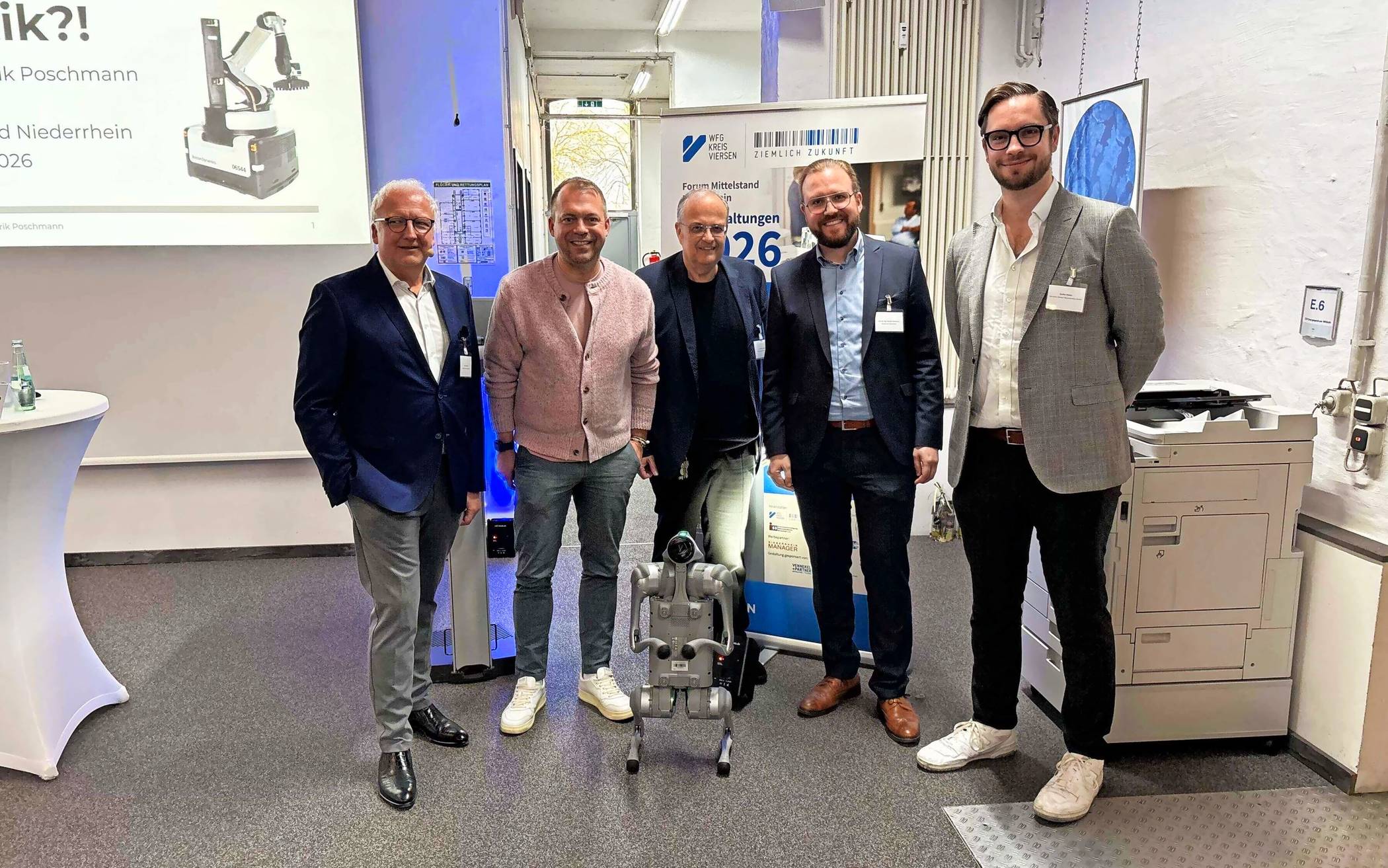  Gruppenbild mit Roboter-Hund: (v.l.) Moderator Prof. Dr. Thomas Merz, Willichs Bürgermeister Christian Pakusch, WFG-Geschäftsführer Dr. Thomas Jablonski, Prof. Dr. Hendrik Poschmann von der Hochschule Niederrhein und Unternehmer Steffen Mallon. Foto: WFG 