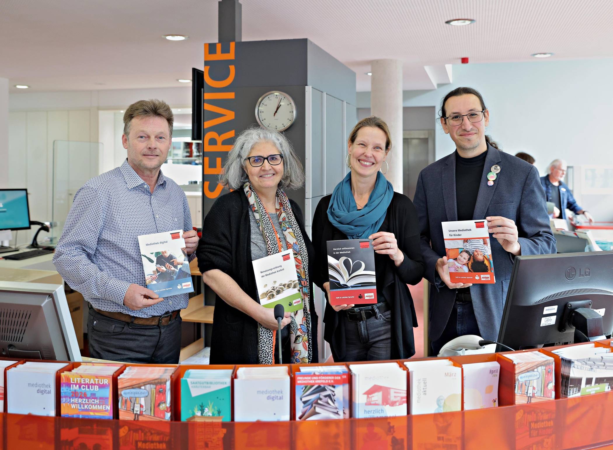 Stellen die Info-Hefte vor: (v.r.): Mediotheksleiter Simon Hoffmann, Projektbetreuerinnen Sabine Smirra von der Mediothek und Silvana Pasquavaglio vom Büro für Leichte Sprache sowie Markus Rinsch, Vorstand der Lebenshilfe.