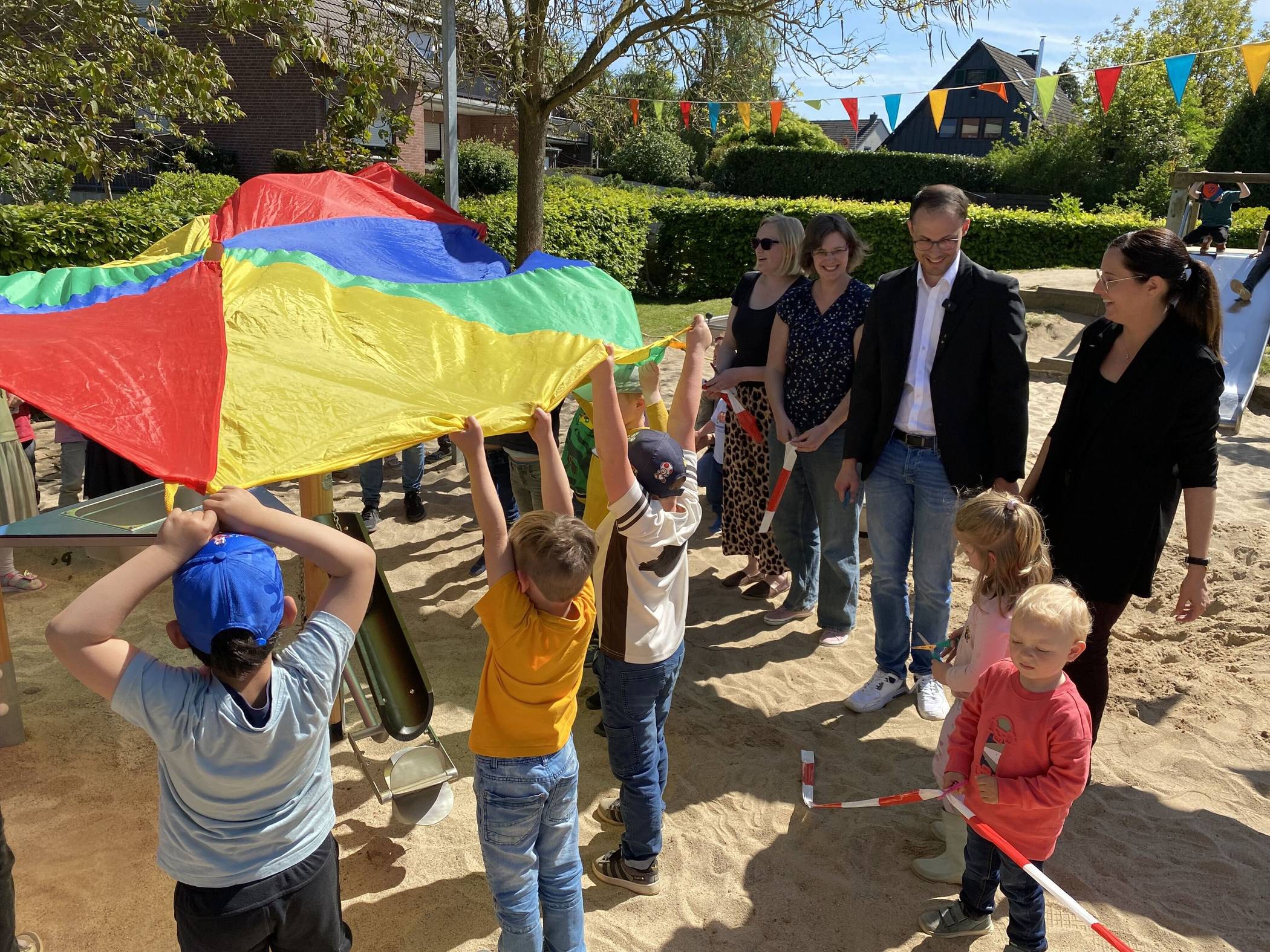  Die Kinder durften das neue Sandspielgerät "enthüllen": Einrichtungsleitung sowie Freunde und Förderer des städtischen Familienzentrums "Drei-Käse-Hoch" bei der Einweihung mit Bürgermeister Kevin Schagen. 