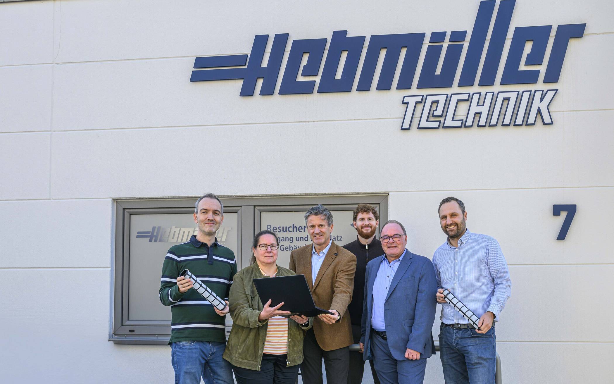 Domnik Hintzen und Robert Abts (3. und 2.v.r., beide Wirtschaftsförderung RKN) mit (v.l.) Julian Joosten, Angelika Brunn, Geschäftsführer Jörg Hebmüller und Jakob Wojtulski (alle Hebmüller GmbH).   