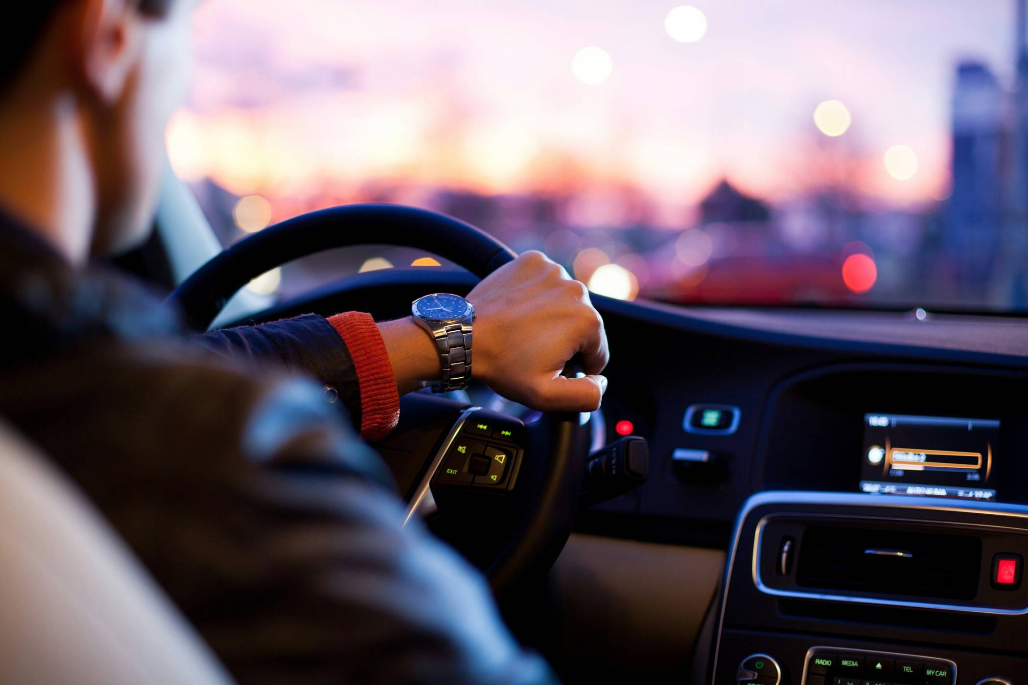  Ein Mann mit Armbanduhr fährt ein Auto. 