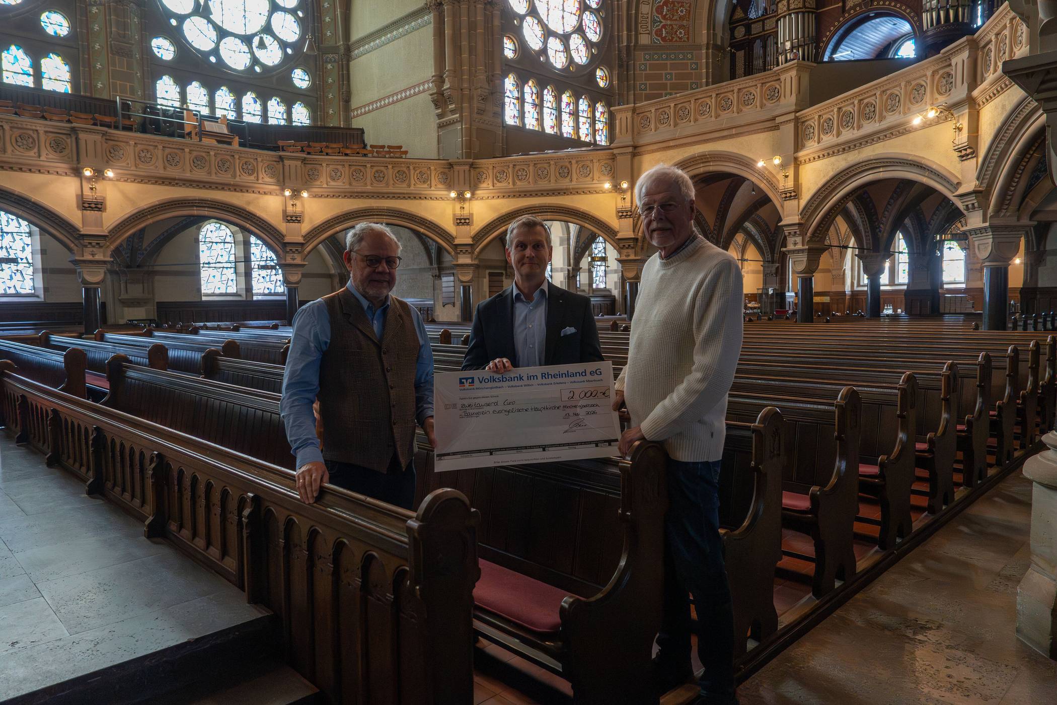 Sven Frauenkron, Generalbevöllmächtigter dder Volksbank im Rheinland eG, kam nicht mit leeren Händen. Er überreichte einen Scheck über 2000 Euro an Jochen Semmler und Bernd Pastors vom Bauverein Ev. Hauptkirche Rheydt e.V..   