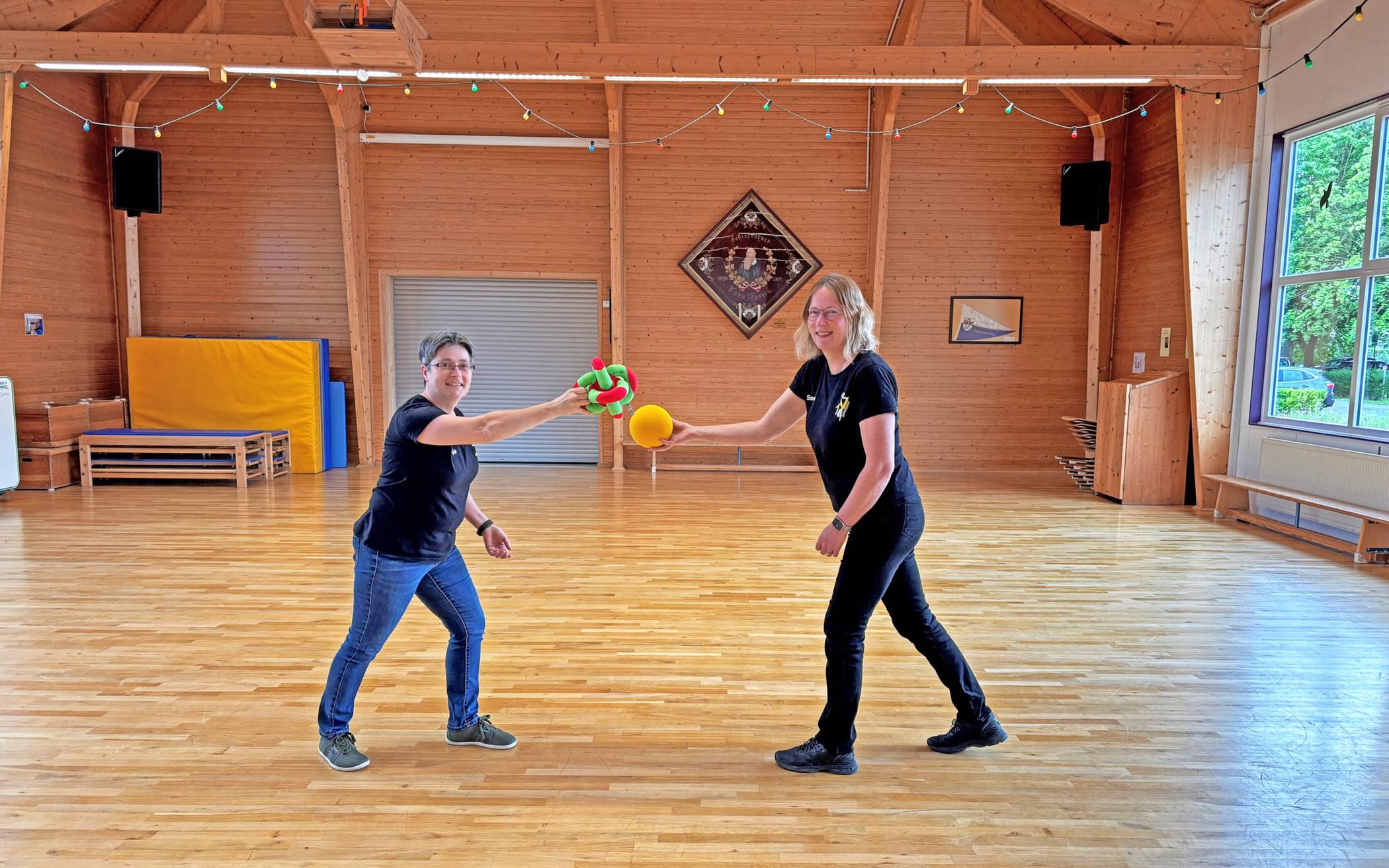 Die Übungen verbinden Bewegungsabläufe mit Gedächtnistraining – auch mit kleinen Geräten oder Bällen, erklären Anja Schröter (li.) und Simone Masum (re.) die Struktur des Angebots  „Sport für Menschen mit Demenz“. 