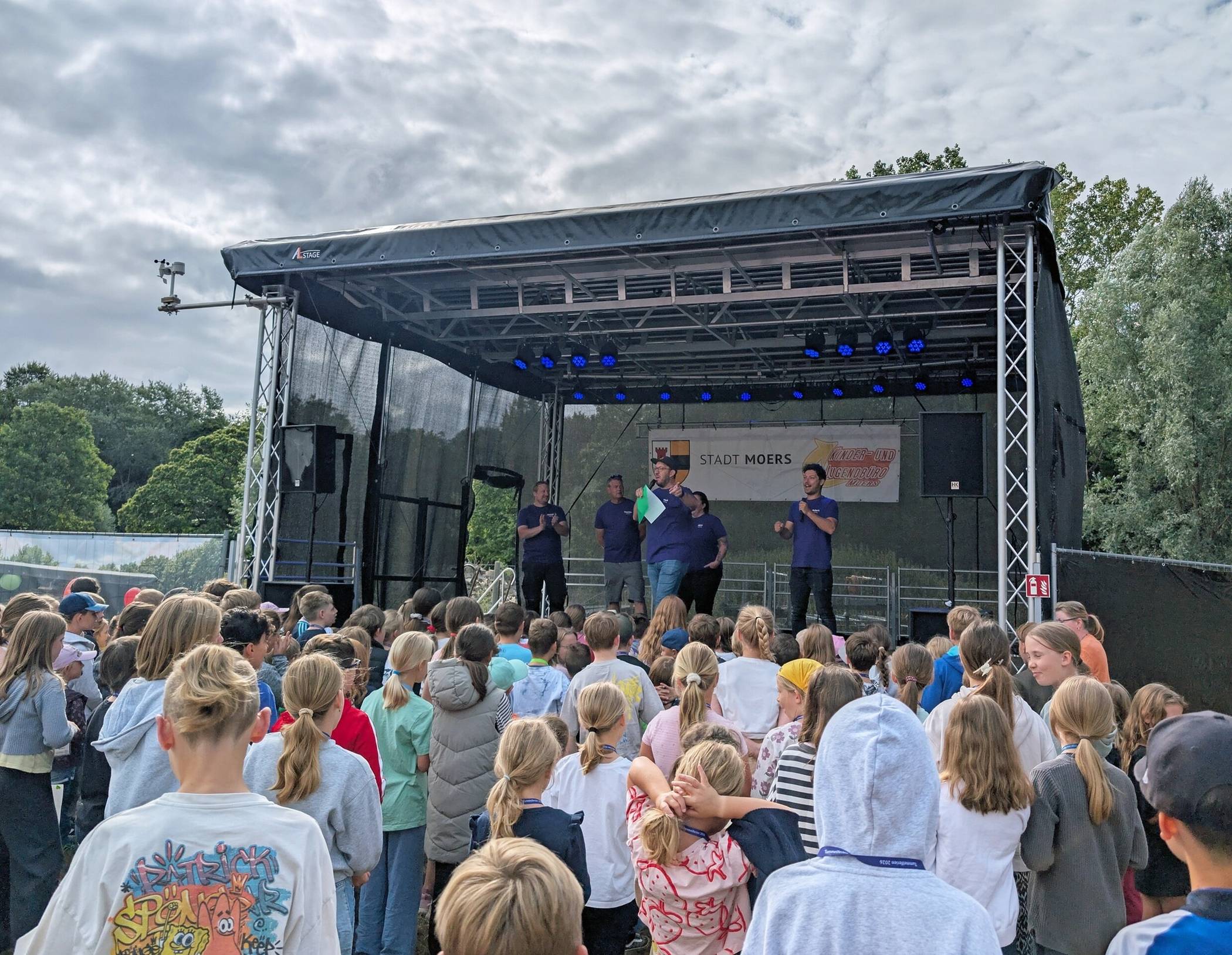 Das Team des Kinder- und Jugendbüros begrüßt die Kids im Freizeitpark von der großen Tummelferien-Bühne. 