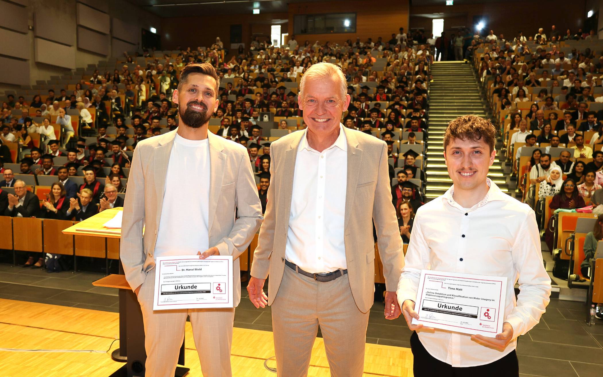 Vorstand Bernd Zibell (Mitte) verlieh vor rund 550 Gästen im Audimax der Universität Duisburg-Essen die Innovationspreise Ingenieurwissenschaften der Sparkasse am Niederrhein an Dr. Marcel Biebl (l.) und Timo Matt (r.). Die Preise sind mit 2.500 Euro und 1.500 Euro dotiert. 
