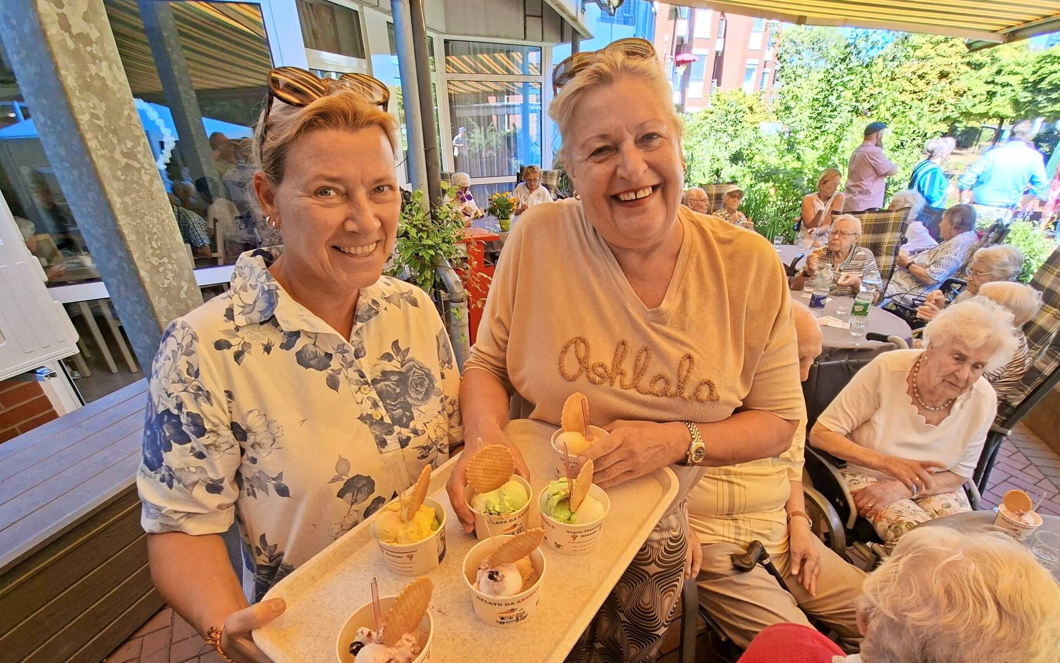  Daniela Schüffel von der städtischen Seniorenberatung (l.) und Marion Holz, deren 98-jährige Mutter Frieda (r., sitzend) im Haus Hildegundis wohnt, verteilen Eis an die Bewohner. 