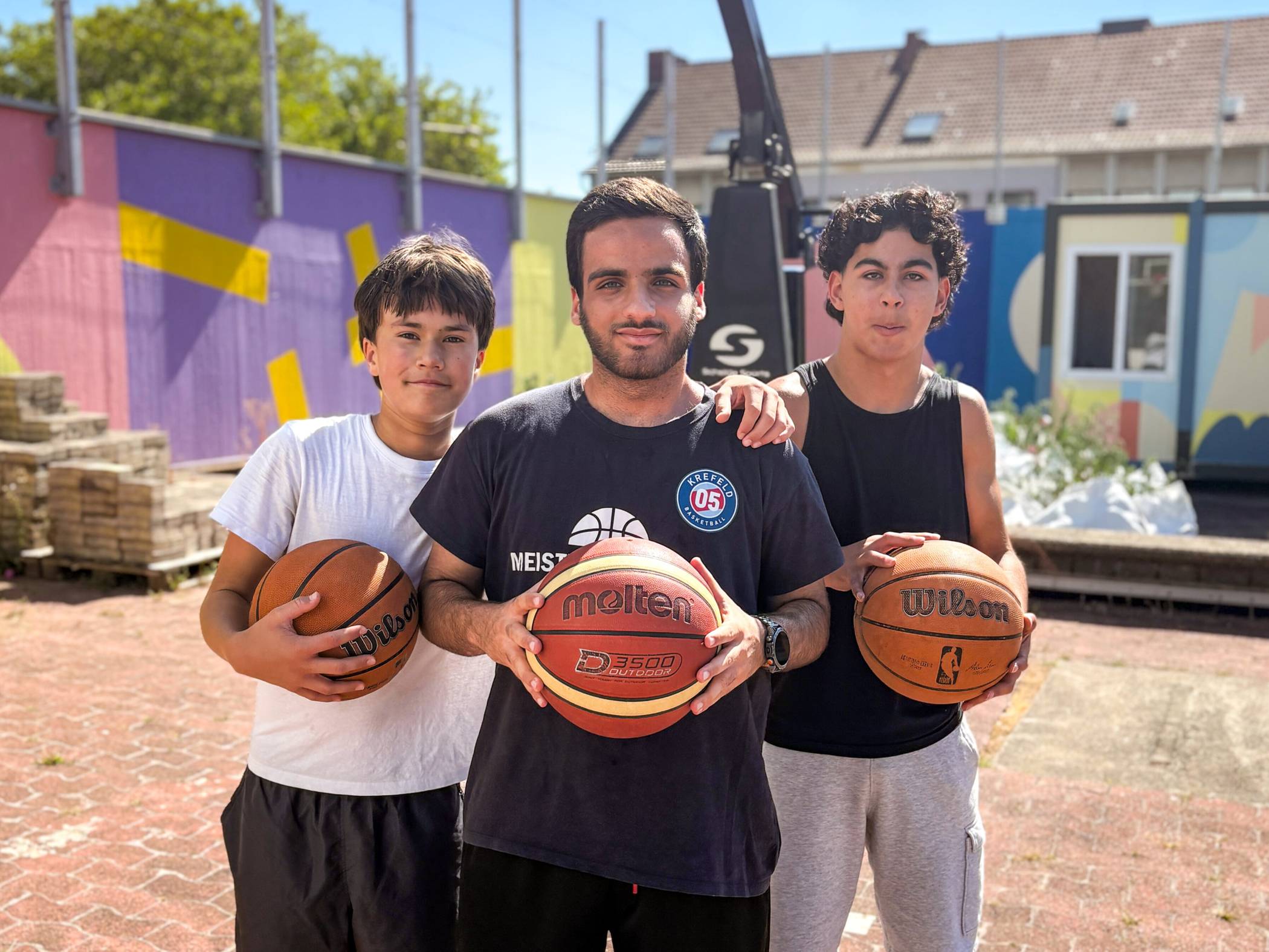 Mohamad Hajouz (Mitte) leitet den offenen Basketball-Treff auf dem Sonnendeck am Bleichpfad. Victor (li.) und Farid bekommen wertvolle Tipps für den Sport