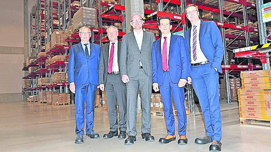 Ralf Meurer, Jens Pries, Oberbürgermeister Sören Link, Damien Germès und Andree Haack beim Gruppenfoto im beeindruckenden Lager von NGK SPARK PLUG EUROPE.