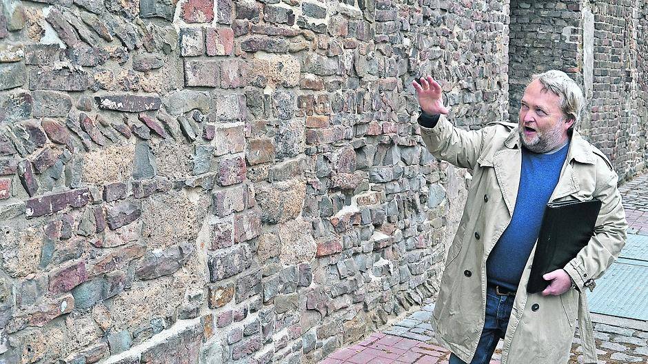Stadtarchäologe Thomas Platz zeigt das älteste Stück Stadtmauer, erkennbar an den schräg verlegten Ziegeln.
