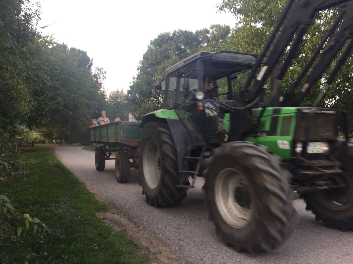 Beim Abtrabsport des Unrats zum Container, gesellten sich die Kinder auf den Traktor-Anhänger.