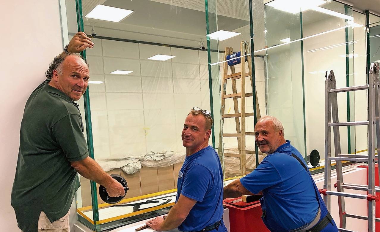  Glasermeister Uwe Fabig (links) und seine Mitarbeiter setzten am Montag eine schusssichere Spezialscheibe in der neuen Sparkassen-Filiale am „Forum Krefeld“ ein. 