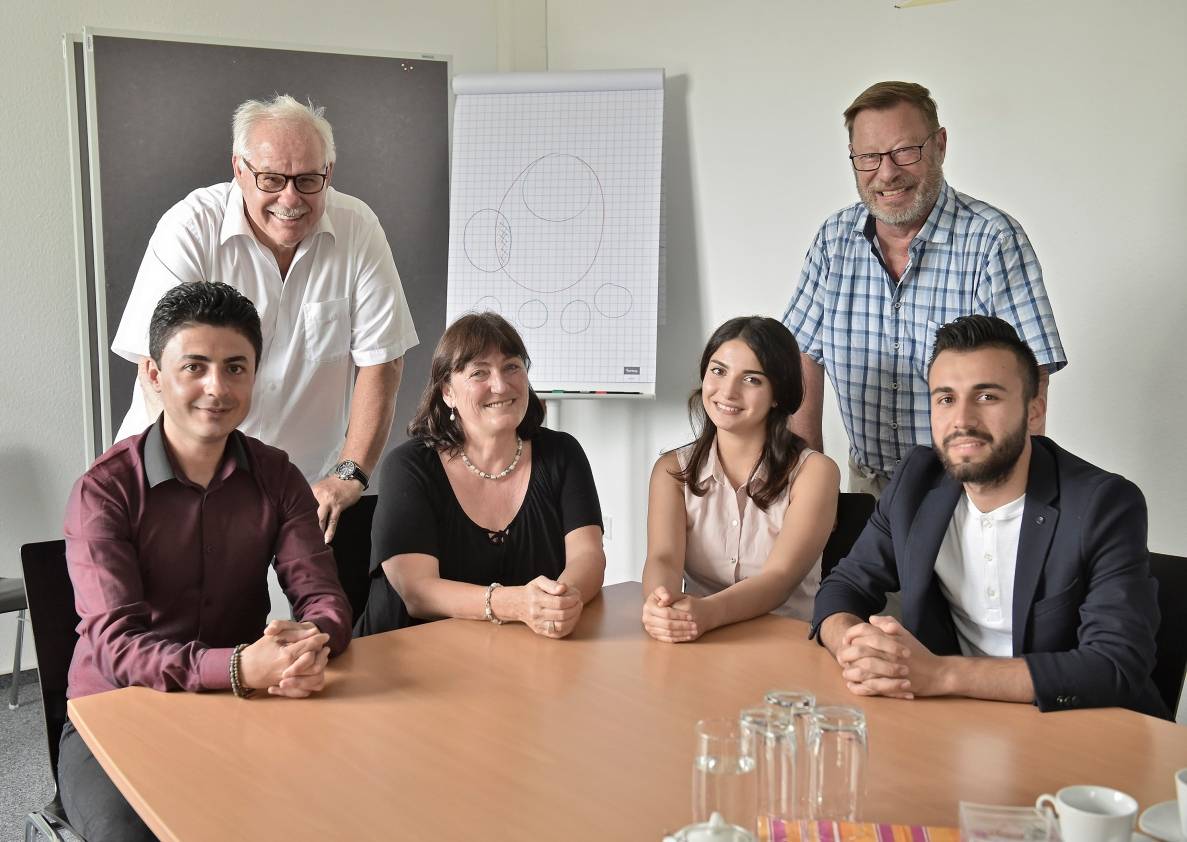Optimistisch: Ehrenamtler Christian Kautz und Karl Heussen (stehend von links) und Flüchtlingskoordinatorin Doris Schlimnat (2. von links) freuen sich über die Erfolge von Arsalan Rahimi (links), Estbraq Alzobaei (2. von rechts) und Mohammed Ragy.