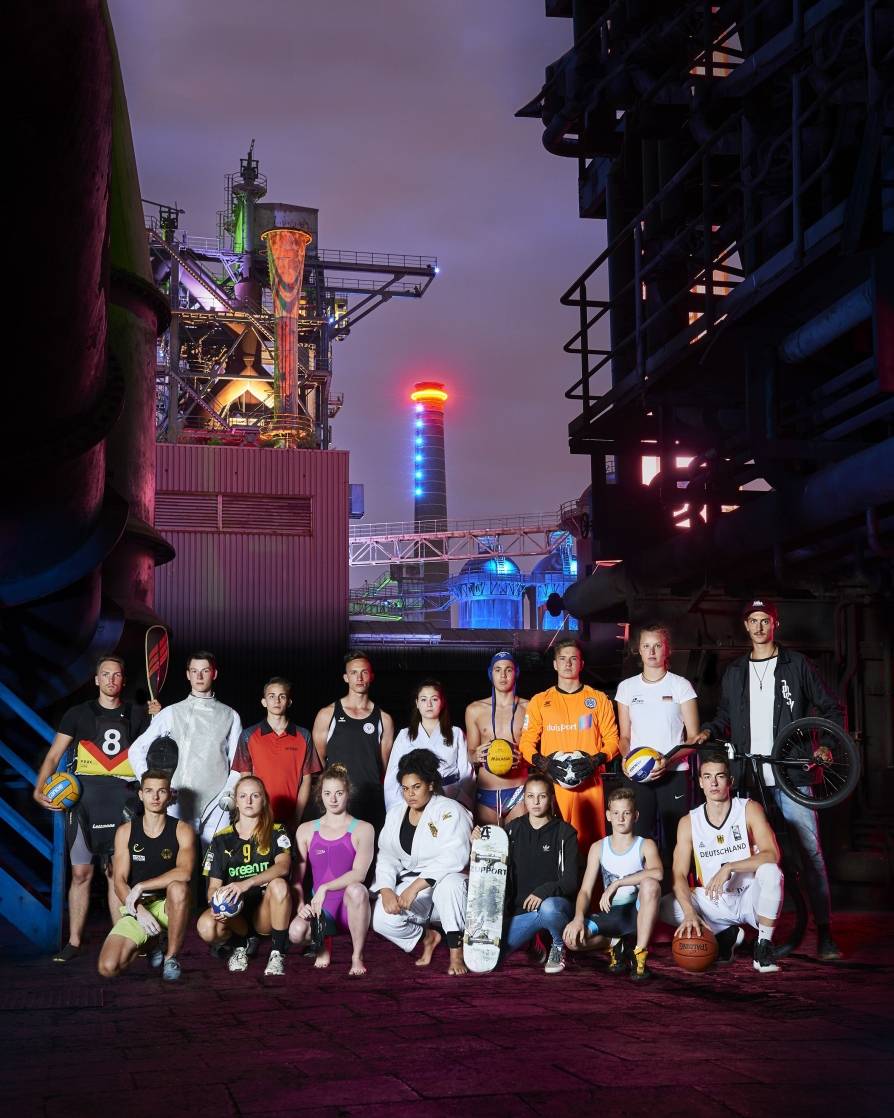 Sportler hinter Hochofenkulisse.