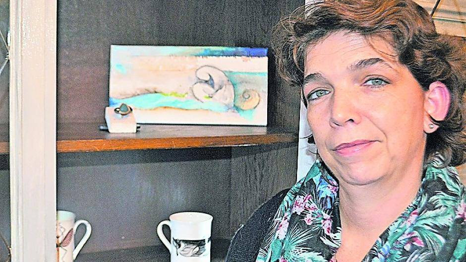 Andrea Thielen-Hirt vor einem restaurierten Schrank mit ein bisschen Kunst — zur Eröffnung wird der natürlich gut gefüllt sein.