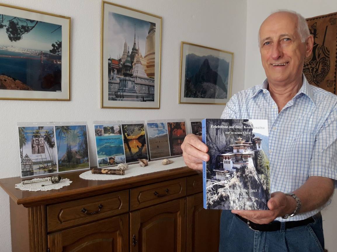  Günter Schäfer mit seinem neuen Buch, das Titelbild zeigt das „Tigernest“, ein Kloster in Paro Bhutan. Im Hintergrund sind die Cover der ersten drei Bände zu sehen. 
