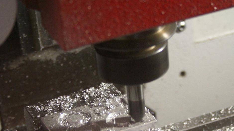  Nachdem die Fräse programmiert wurde, muss das Werkstück eingelegt werden. Dies geschieht nach entsprechender Einweisung. Danach fräst die Maschine....  