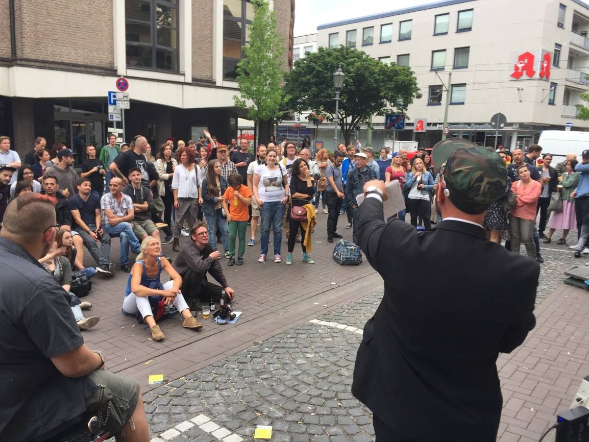  Der Herr Geschäftsführer bei der Arbeit: KSL-Initiator Ben Perdighe leitet die Kunstauktion beim letztjährigen „Kunst statt Leerraum“-Festival vor dem besetzten und mit allerlei Kunst verziertem Haus des Handwerks an der Kolpingstraße. 