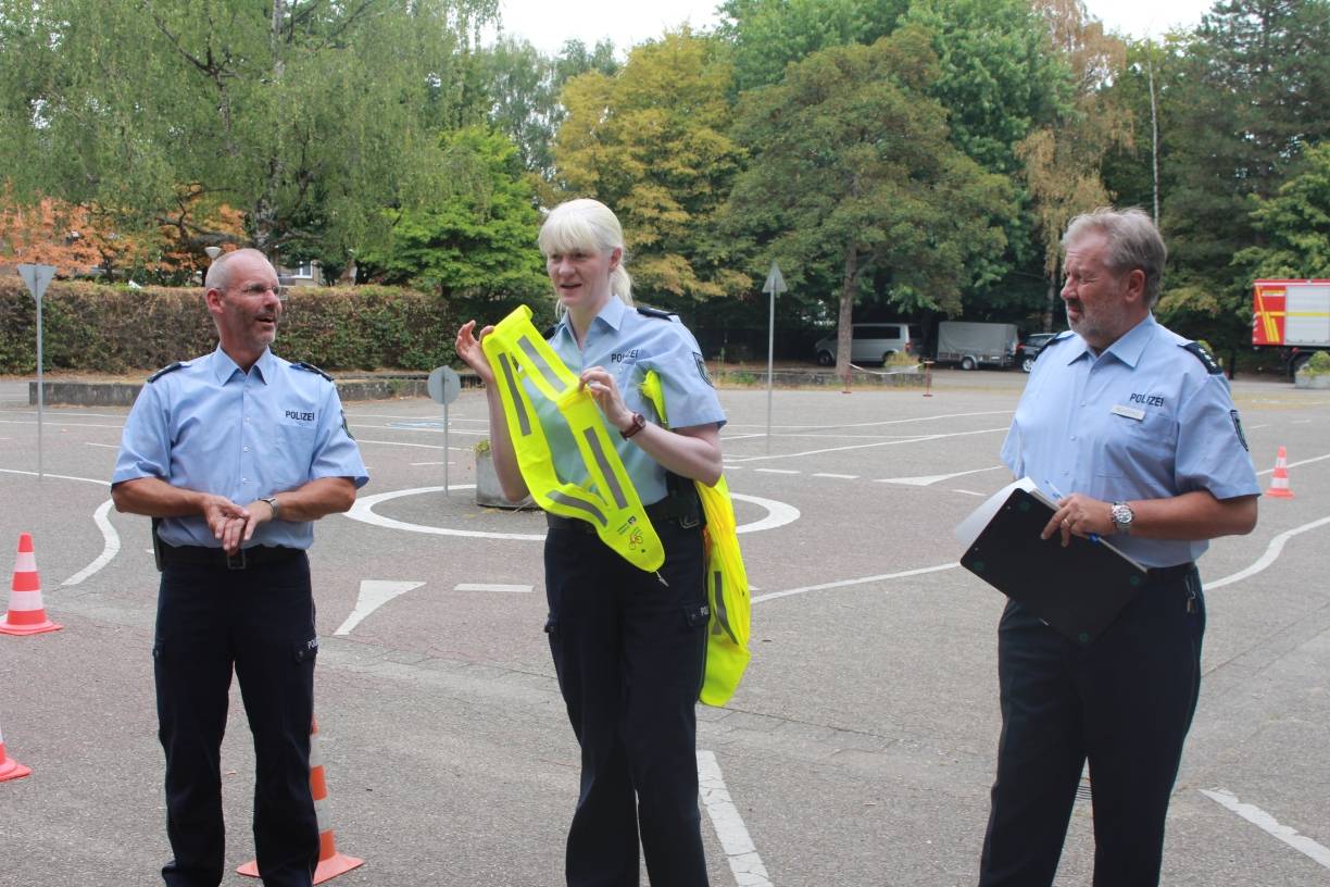 Die Verkehrspolizisten (v.l.) Helmut Bott, Manuela Letzelter und Rainer Behrens geben eine erste Einführung. Dazu gehört die Empfehlung an die Radfahrer, eine Sichtschärpe zu tragen.