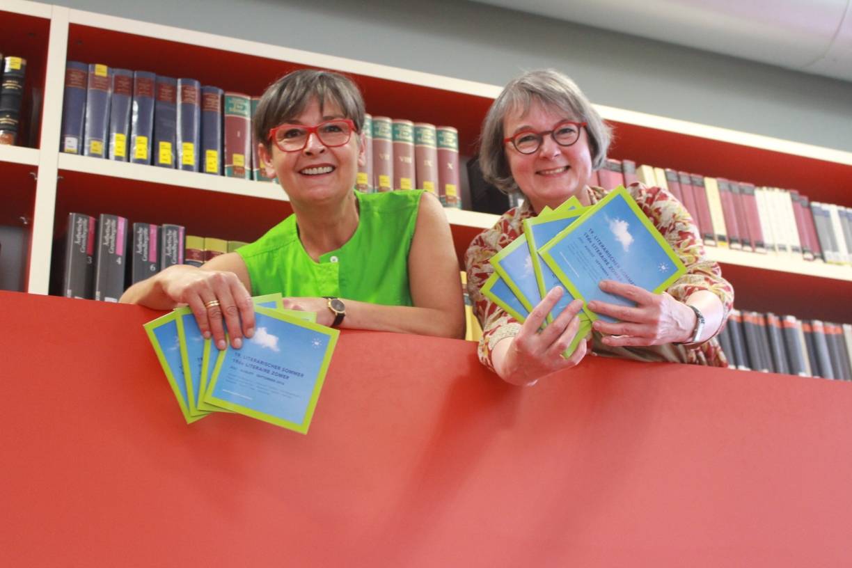  Programm kompakt: Die Leiterin des Niederrheinischen Literaturhauses Anette Ostrowski (l.) und die Direktorin der Mediothek Evelyn Buchholtz empfehlen das Info-Heft des Literarischen Sommers mit allen Veranstaltungen und Kontaktadressen. Es liegt an öffentlichen Stellen zum Mitnehmen aus. 