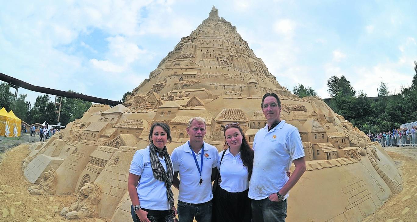  Vier der insgesamt 19 Sandkünstler vor der offiziell größten Sandburg der Welt im Rekordsommer im Landschaftspark Nord. 