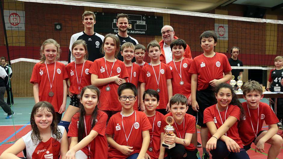  Marketingchef Heiner Rütjes (hinten rechts) überreichte zum Abschluss des Adler-Sparkassen-Cups viele Pokale. Hier feiern die Mädchen und Jungen der Eichendorfschule ihren 3. Platz in der Gesamtwertung. Die MSC-Spieler Jonas Hoppe und Lukas Schattenberg (dahinter) freuen sich mit den Kindern. 