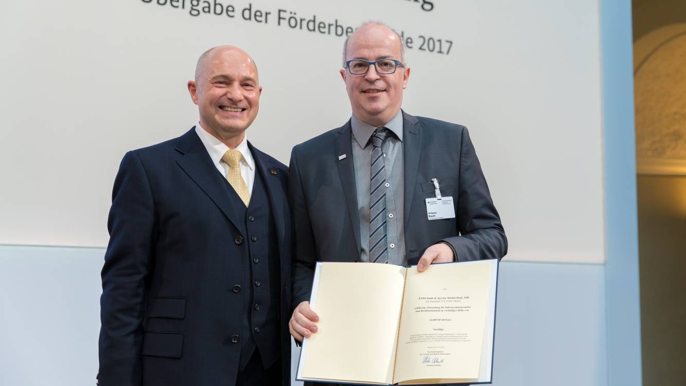 Wolfgang Baum (rechts), verantwortlich für die Unternehmensentwicklung der ENNI Stadt &amp; Service, bei der Übergabe des Förderbescheids durch Rainer Bomba, Staatssekretär im Bundesverkehrsministerium, in Berlin.