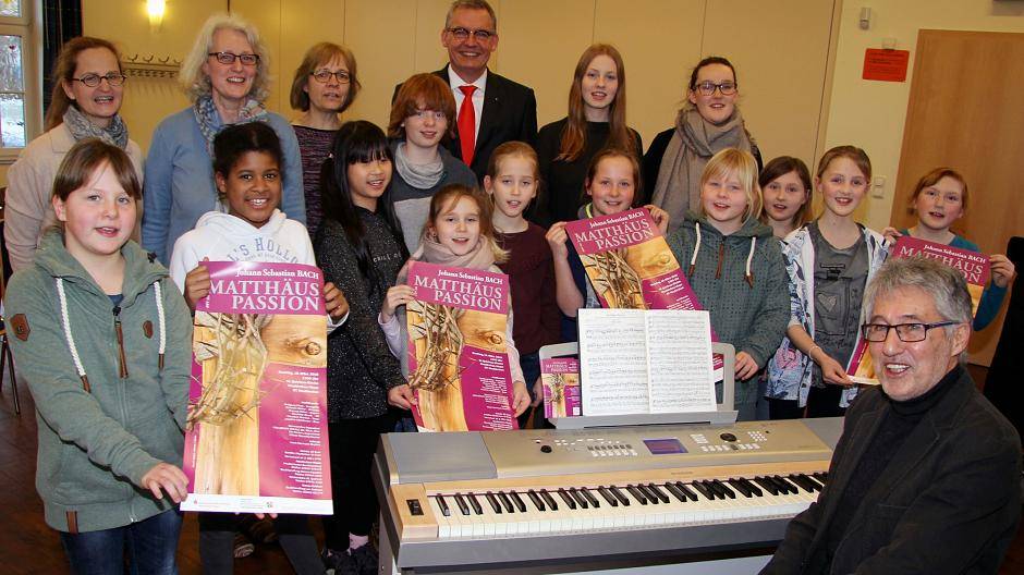  Hans-Hermann Buyken (rechts) brachte zur Probe ins evangelische Gemeindehaus Vluyn die ersten Plakate für die Matthäus Passion mit. Zusammen mit den Kindern und den Chorleiterinnen Claudia Naujoks (2.v.l.) und Susanne Weber-Spickers (rechts daneben) sang sich Sparkassenvorstand Bernd Zibell mit ein. 