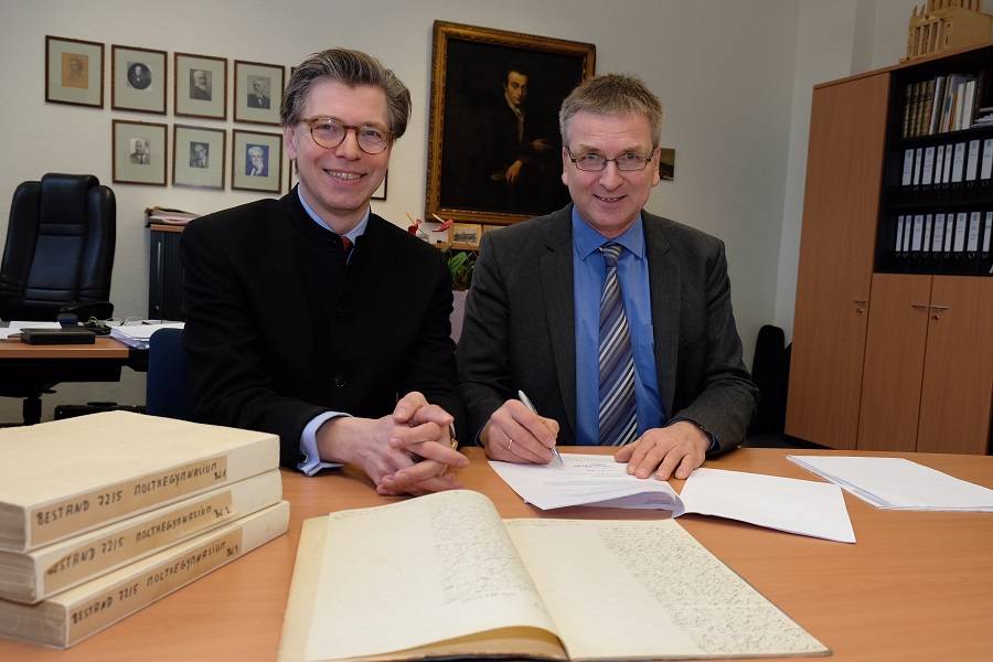Dr. Olaf Richter, Leiter des Stadtarchivs (l.), und Dr. Uda Rademacher, Leiter des Gymnasiums am Moltkeplatz, unterschreiben den Hinterlegungsvertrag.