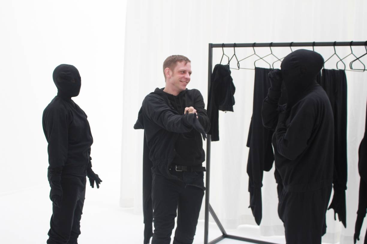  Nur Mut: Im Vorraum des gänzlich weißen Saals ziehen sich die Besucher Ganzkörperkostüme in tiefem Schwarz über. So verschwindet die Individualität zum kollektiven Körper. 