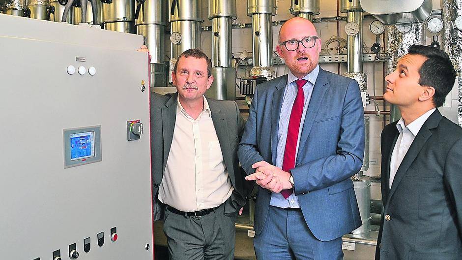 Jürgen Dietz, Betriebsleiter DuisburgSport, Oberbürgermeister Sören Link und der Bundestagsabgeordnete Mahmut Özdemir (v.l.) neben dem neuen Blockheizkraftwerk im Rhein-Ruhr-Bad.