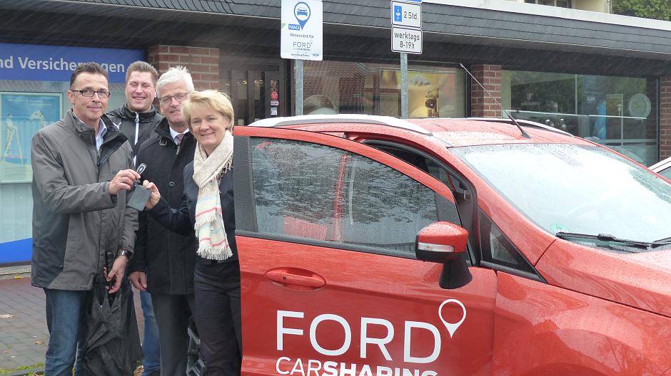  Stefanie Kluge übergibt symbolisch den Schlüssel des Carsharing-Fahrzeuges an Bürgermeister Prof. Dr. Christoph Landscheidt, in der Mitte NIAG-Vorstand Peter Giesen und hinten Rene Böhm, Klimaschutzmanager der Stadt Kamp-Lintfort. 
