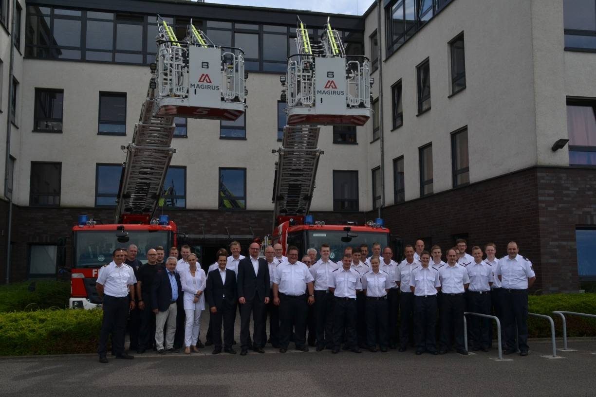  Gruppenfoto vor den zwei neuen Drehleiterwagen der Feuerwehr Duisburg an der Feuerwache in Homberg. 