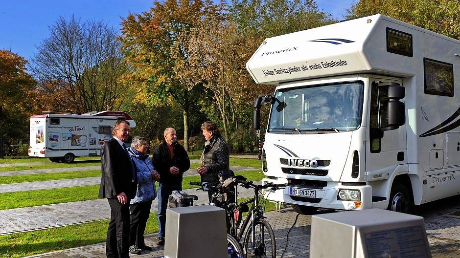 Bei strahlendem Sonnenschein begrüßen Bürgermeister Christoph Fleischhauer (r) und Dirk Hohensträter, Geschäftsführer der ENNI Sport &amp; Bäder (l), das Camperpaar Norbert und Klara Holewik aus der Oberpfalz.
