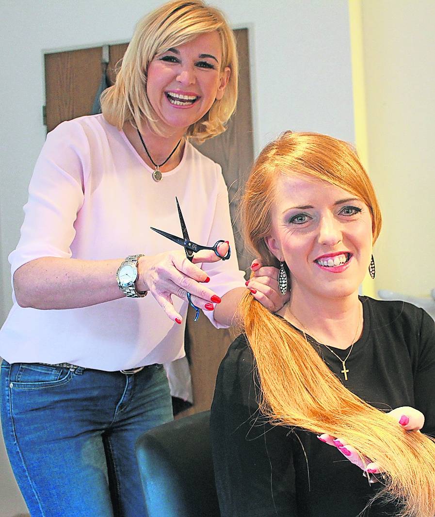  Der Zopf muss jetzt fallen: Friseurmeisterin Dunja Nieskens zückt schon die Schere. Kundin Corinna Bubacz möchte sich von ihrem langen Haar trennen, so schön es auch ist. 