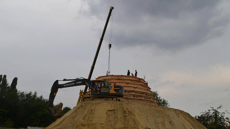 standen Kran und Bagger bereit, den Sand in luftige Höhe zu...