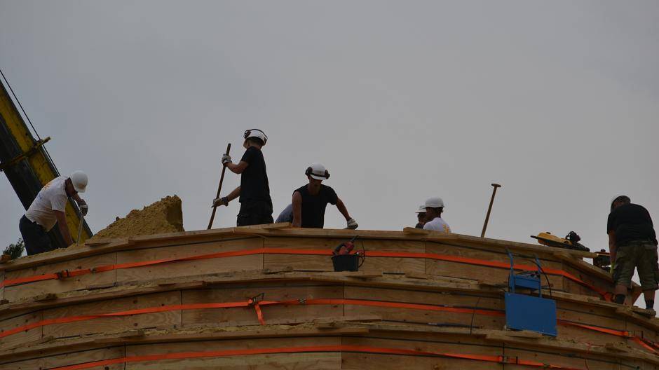 Auf dem "Gipfel" wird der Sand von den zahlreichen Künstlern und Helfern gleichmäßig...