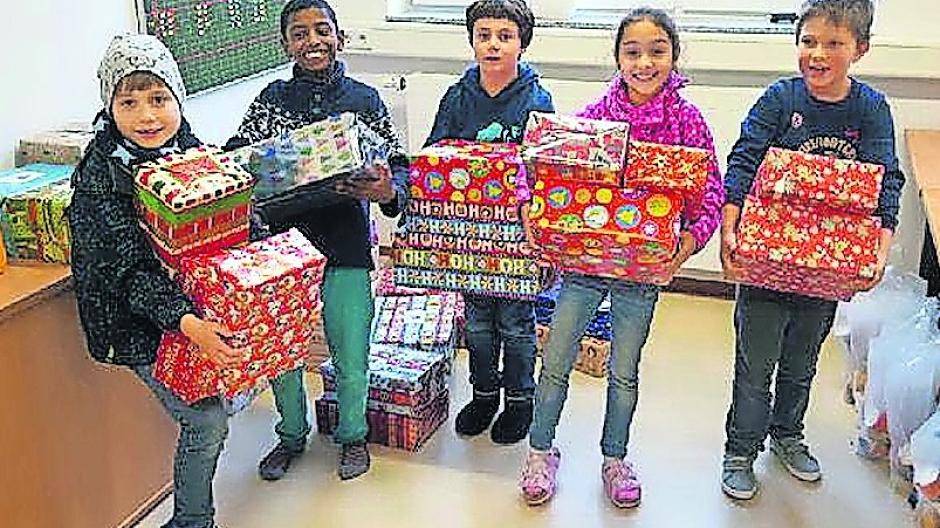 Die Kinder freuen sich sichtlich über die Weihnachtsgeschenke aus Deutschland. Fotos (2): Round Table