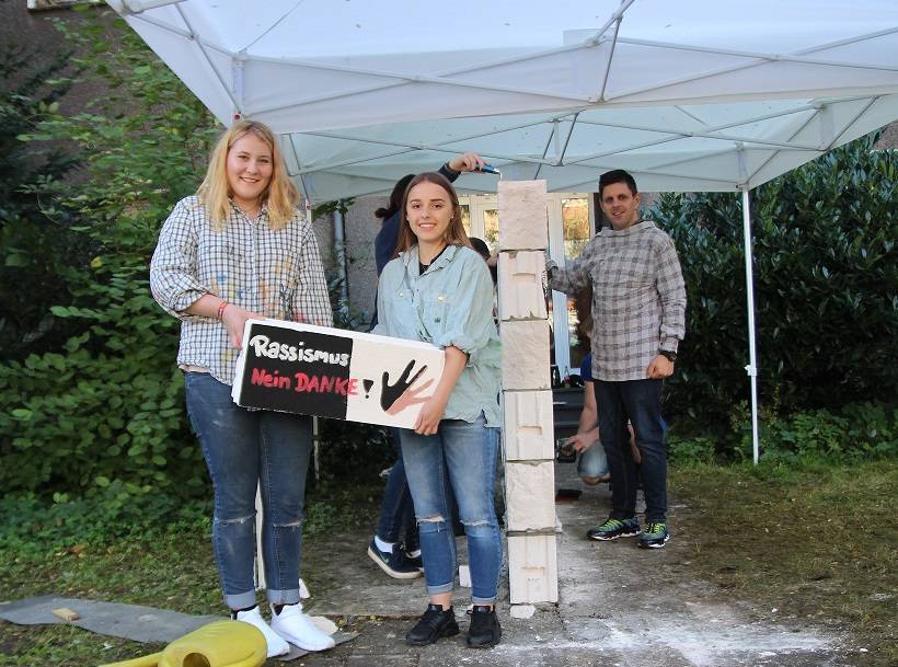 Annika aus Oermten und Kim aus Sevelen mit einem der Mauersteine.
