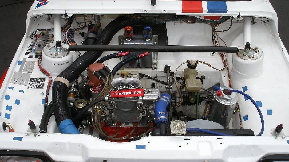 Ein Blick in den Motorraum eines Fiat 127 (2. Serie). Man beachte die Abflussstopfen in...